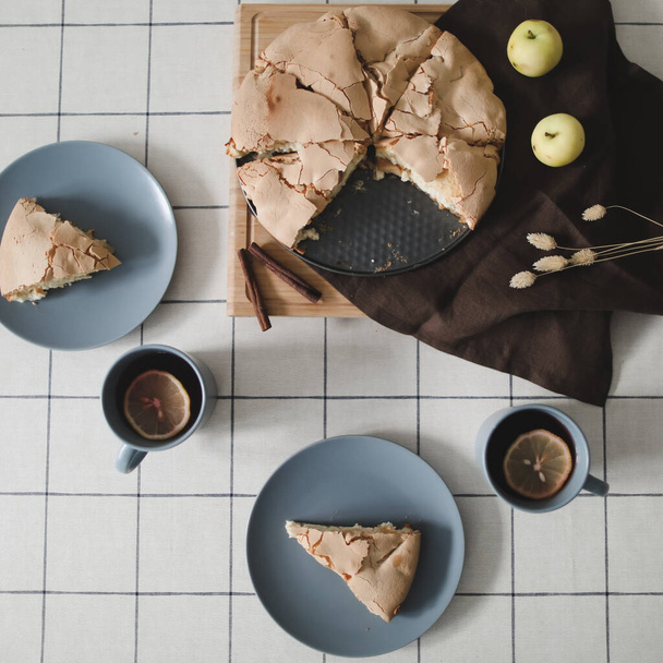 Pieces of delicious apple pie. Composition with tasty homemade apple pie, cinnamon and apples on table. Flat lay. Top view - Fotografie, Obrázek