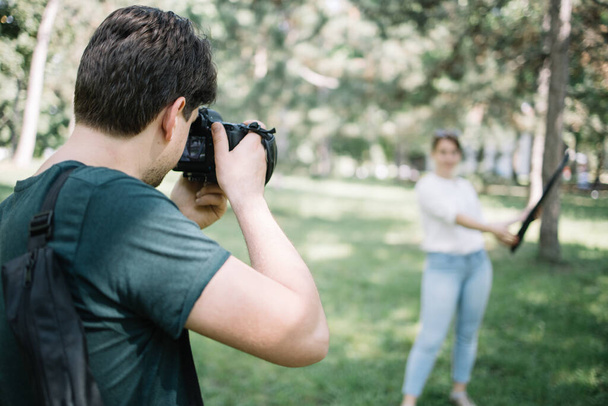 Photographer taking photos of blurred woman with reflector - Valokuva, kuva