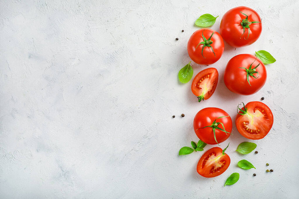 Tomates fraîches mûres et feuilles de basilic sur fond blanc. Vue de dessus. Espace de copie. - Photo, image
