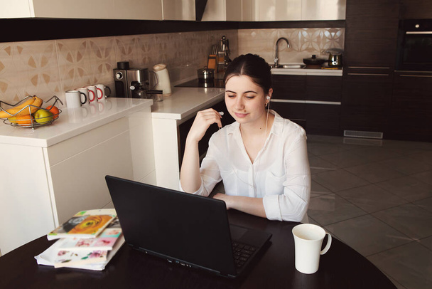 Jonge vrouw werkt, studeert thuis op laptop. Werken vanuit huis. Concept home quarantaine, preventie COVID-19, Coronavirus uitbraak situatie - Foto, afbeelding