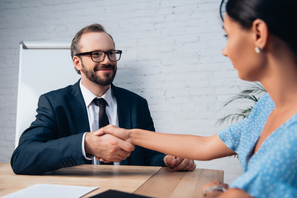 selective focus of bearded lawyer in glasses shaking hands with client in office  - Foto, Imagem