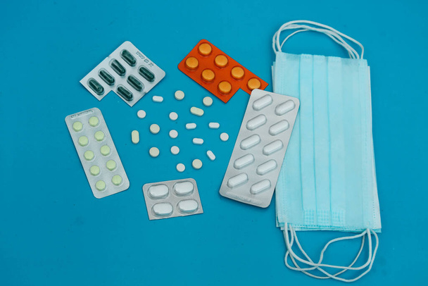 Surtido de tabletas y cápsulas de medicamentos farmacéuticos. Varias tabletas de medicamentos sobre fondo azul. - Foto, Imagen