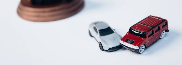 plano panorámico de coches de juguete en blanco, concepto de seguro  - Foto, imagen