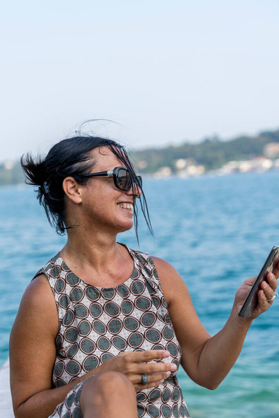 pretty woman on vacation uses smartphone to share content on social networks - Fotoğraf, Görsel