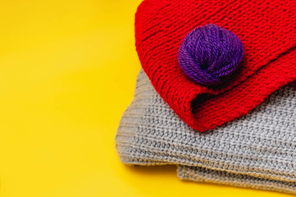 part of a knitted grey sweater on a yellow background - Photo, Image