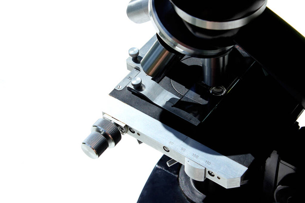 Microscopio negro sobre fondo blanco, vista horizontal. Medicina, ciencia, concepto de investigación. - Foto, Imagen