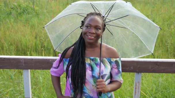 elegante dama afroamericana con paraguas cerca de pasamanos - Metraje, vídeo