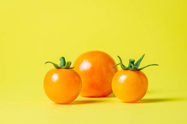 Žlutá rajčata na žlutém pozadí. Zralá šťavnatá rajčata. Odrůda rajčat - Fotografie, Obrázek