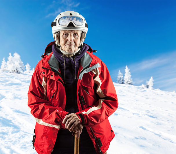 Vanhempi nainen yllään hiihtotakki luminen rinne
 - Valokuva, kuva