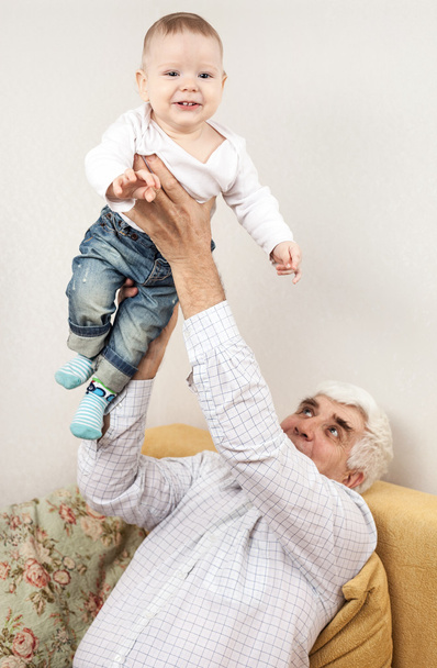 Großvater hält Enkel auf Sofa fest - Foto, Bild