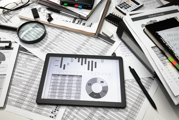 ビジネスオフィスデスククローズアップ-画面上のテーブルとグラフを持つタブレットコンピュータ、財務報告、分析と会計、帳簿書類のセット - 写真・画像