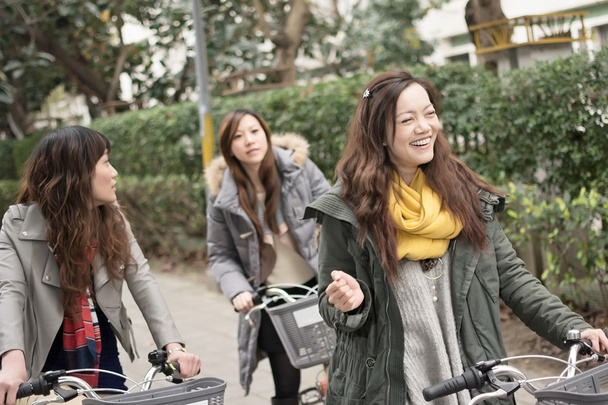 Jeune femme asiatique à vélo avec des amis
 - Photo, image