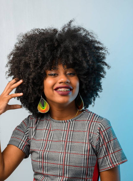 красивая молодая чернокожая женщина, ухаживающая за своими волосами - Фото, изображение