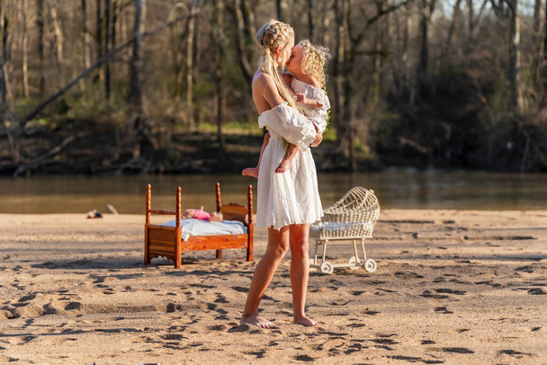 Una hermosa joven madre y su hija disfrutan del clima primaveral - Foto, Imagen