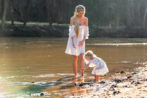 Genç ve güzel bir anne ve kızı bahar havasının tadını çıkarıyorlar. - Fotoğraf, Görsel
