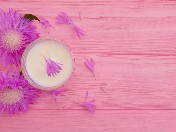 crème cosmetische bloem op houten achtergrond - Foto, afbeelding