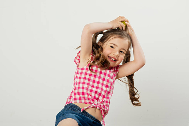 cute happy kid girl playing with fruit smiling and having fun - Φωτογραφία, εικόνα