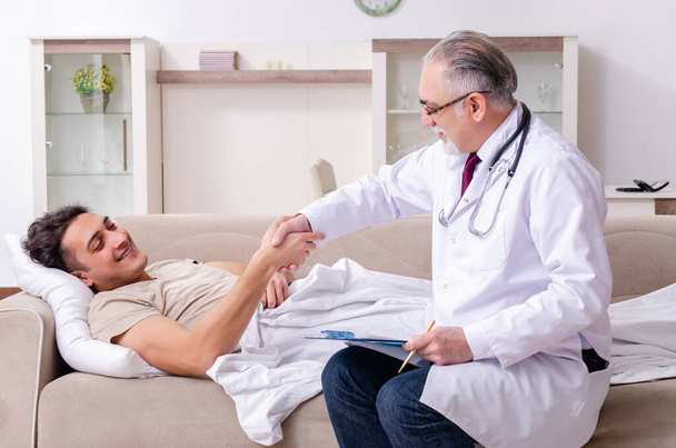 Old male doctor visiting young male patient - Photo, Image