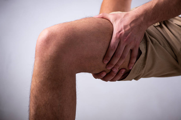 Young man suffering from leg pain - Valokuva, kuva