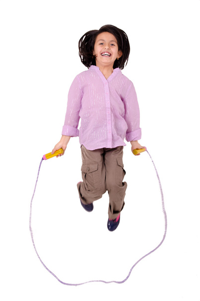 Seven year Girl jumping with skipping rope isolated on white - 写真・画像