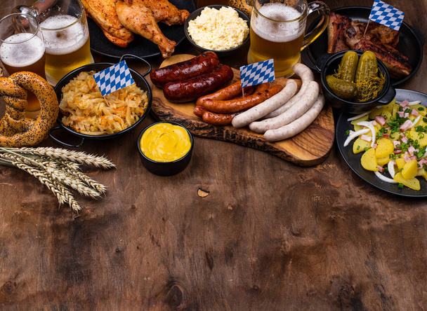Platos Oktoberfest con cerveza, pretzel y salchicha - Foto, Imagen