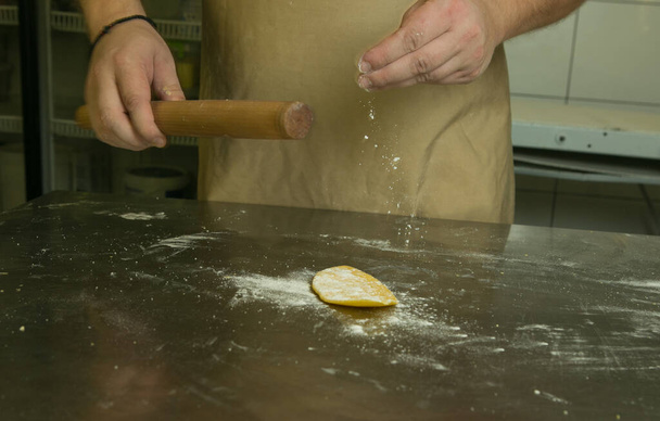 Healthy food concept. The process of making natural egg noodles. The chef's hands roll out the dough. - Photo, Image