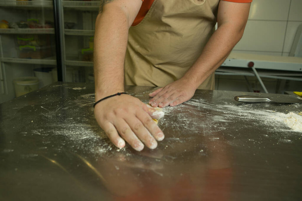 Концепція здорової їжі. Процес приготування натуральної яєчної локшини. Руки шеф-кухаря готують тісто для різання
. - Фото, зображення