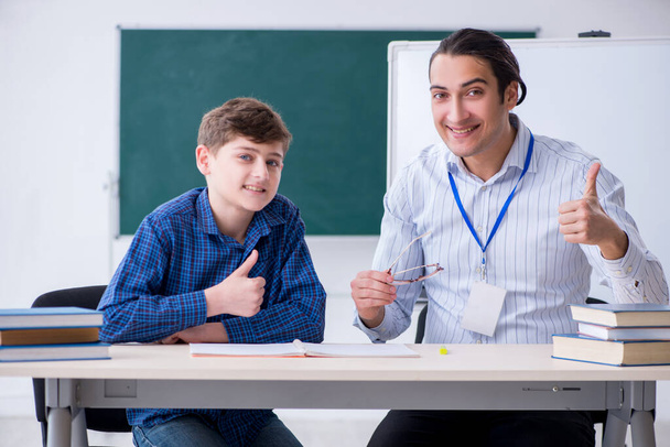 Молодий вчитель чоловічої статі і хлопчик в класі
 - Фото, зображення