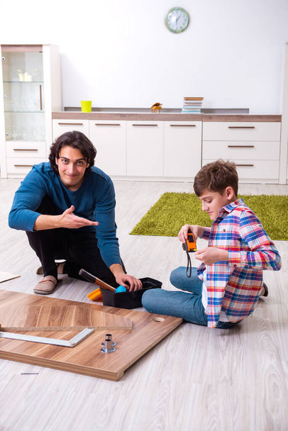 Young carpenter teaching his son - Фото, изображение