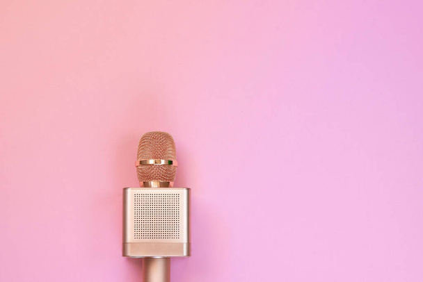 Золотий мікрофон караоке на рожевому тлі, вид зверху. концепція запису мікрофона караоке мікрофон на рожевому фоні
. - Фото, зображення