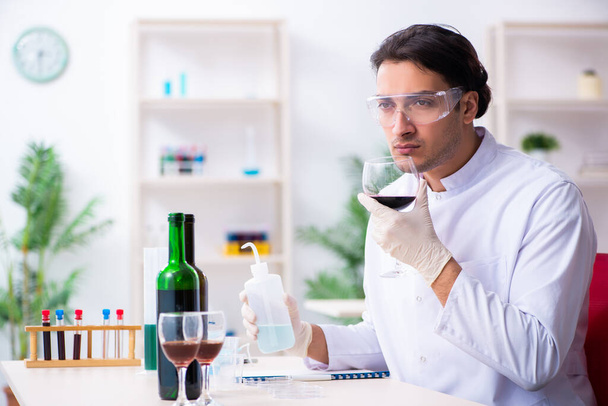 Mužský chemik vyšetřuje vzorky vína v laboratoři - Fotografie, Obrázek