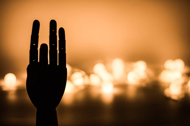 Silhouette de main en bois avec fond de lumières dorées floues - Photo, image