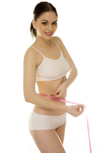 Shapely slender woman measuring her waist - Zdjęcie, obraz