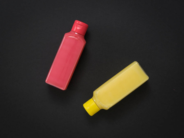 Two plastic bottles with soap solution on a black background. - Photo, Image