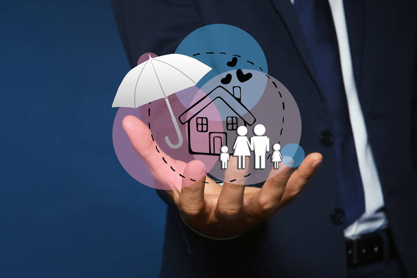 Insurance concept - umbrella demonstrating protection. Man with illustrations on dark background, closeup - Фото, изображение