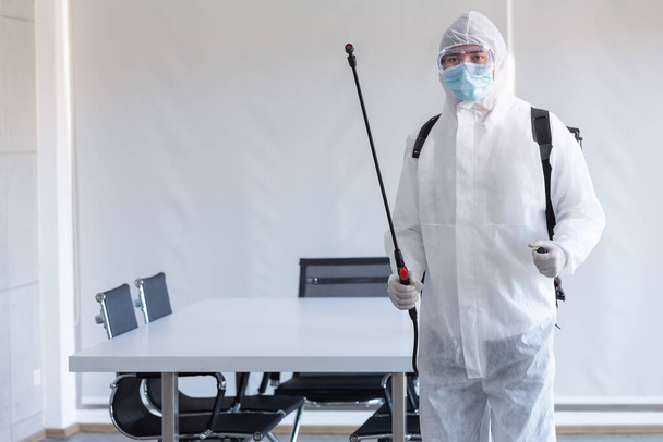 Cleaning and Disinfection at meeting room amid the coronavirus epidemic Professional teams for disinfection efforts Infection prevention and control of epidemic Protective suit and mask. - Photo, Image
