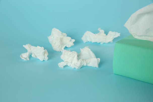Used paper tissues and box on light blue background - Φωτογραφία, εικόνα
