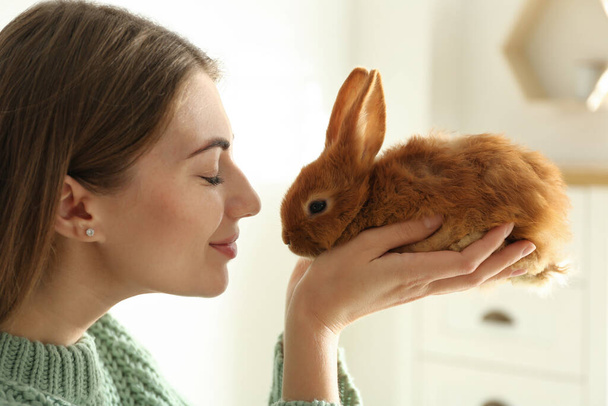 Young woman with adorable rabbit indoors, closeup. Lovely pet - Fotografie, Obrázek