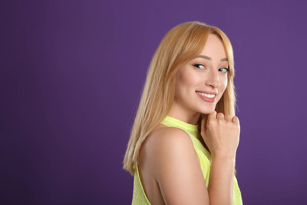 Beautiful young woman with blonde hair on purple background - Photo, Image