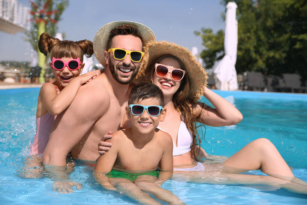 Happy family in swimming pool on sunny day - Фото, зображення