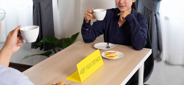 Sitzen und Kaffee und Snacks essen, die Abstand halten - Foto, Bild