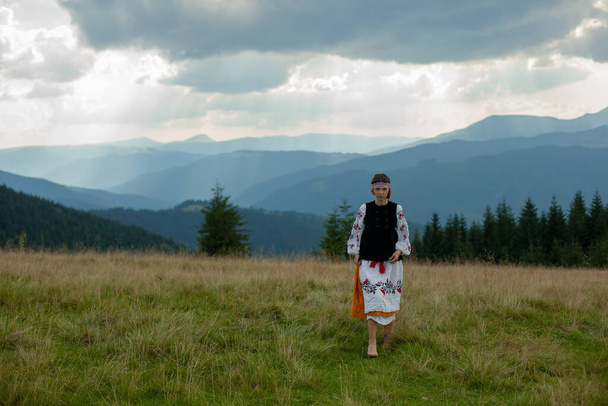 girl in embroidery in the carpathians on a cloudy sunny summer day - Fotografie, Obrázek