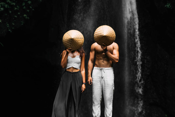 A couple in love on vacation in Asia. The couple is vacationing in the tropics. Beautiful couple at the waterfall. Vacation on the island of Bali. Honeymoon trip. Beautiful lovers. Copy space - Foto, Imagem