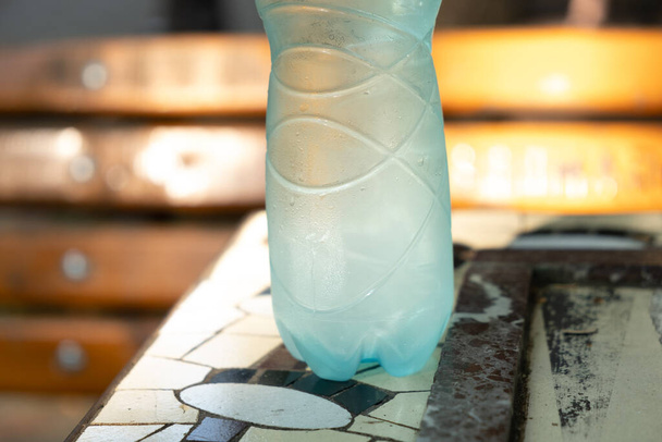 Bottiglia di acqua sudata su un tavolo nel parco in una giornata estiva. Foto di alta qualità - Foto, immagini