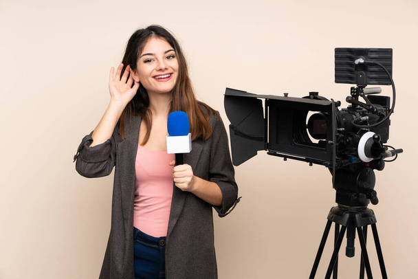 Reporter donna in possesso di un microfono e la segnalazione di notizie su sfondo isolato ascoltare qualcosa - Foto, immagini