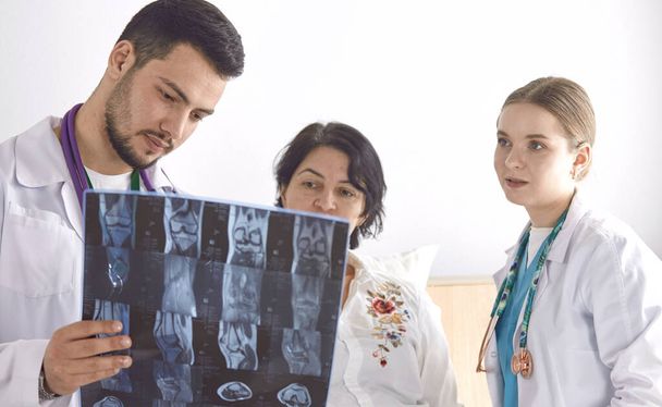 Lékař sledující rentgenovou fotografii starší ženy - Fotografie, Obrázek