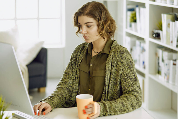 Mujer joven trabajando con tableta gráfica en la oficina
 - Foto, imagen