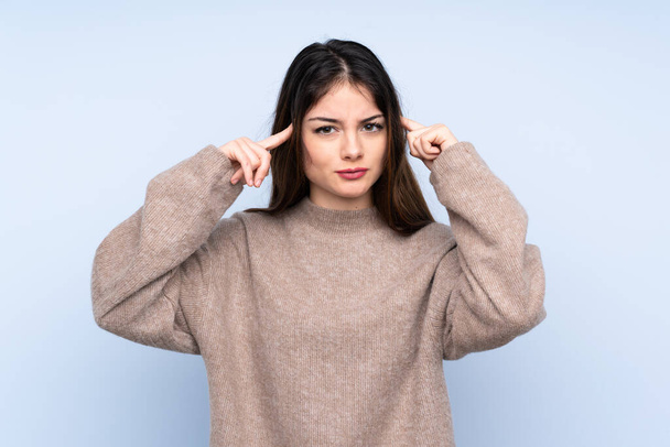 Young brunette woman wearing a sweater over isolated blue background having doubts and thinking - Fotó, kép