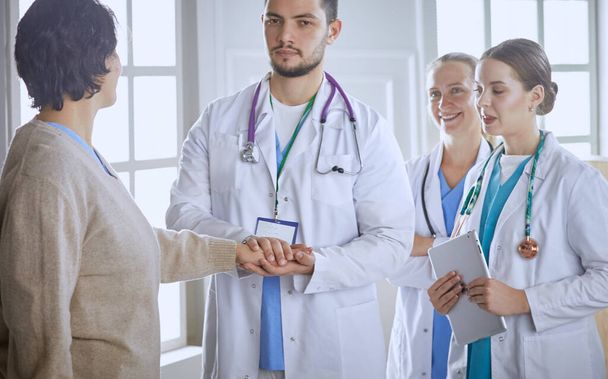 Paciente com um grupo de médicos em segundo plano
 - Foto, Imagem
