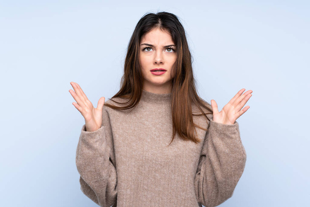 Young brunette woman wearing a sweater over isolated blue background frustrated by a bad situation - Photo, Image